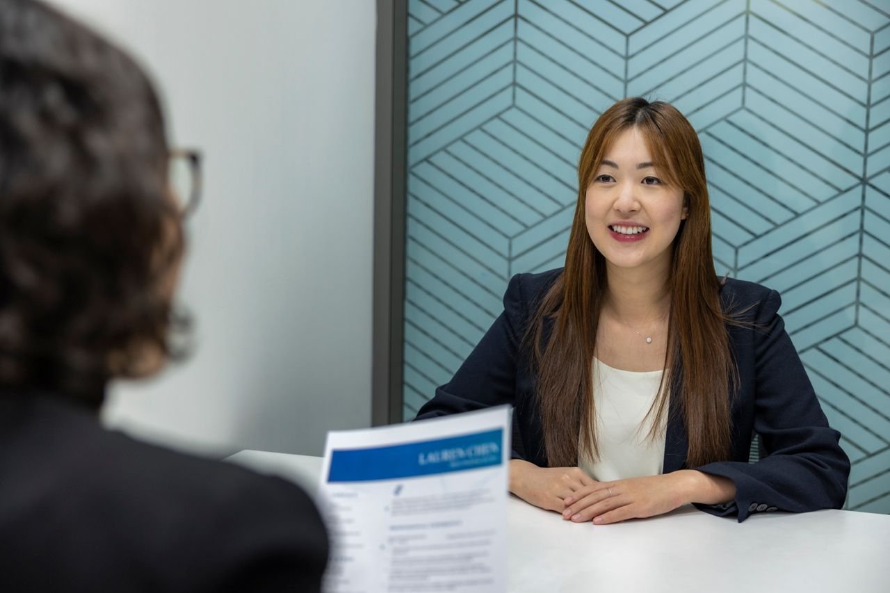 about-img Young woman in a business meeting with an interviewer, showcasing confidence and professionalism.